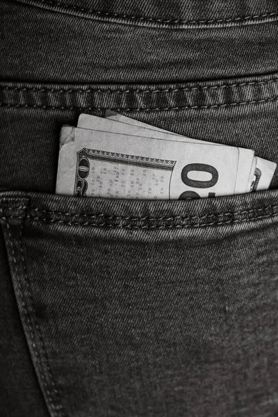 Banknotes close up, money in a jeans pocket. Dollars stick out of the jeans pocket, finance and currency concept. Concept of saving or spending money