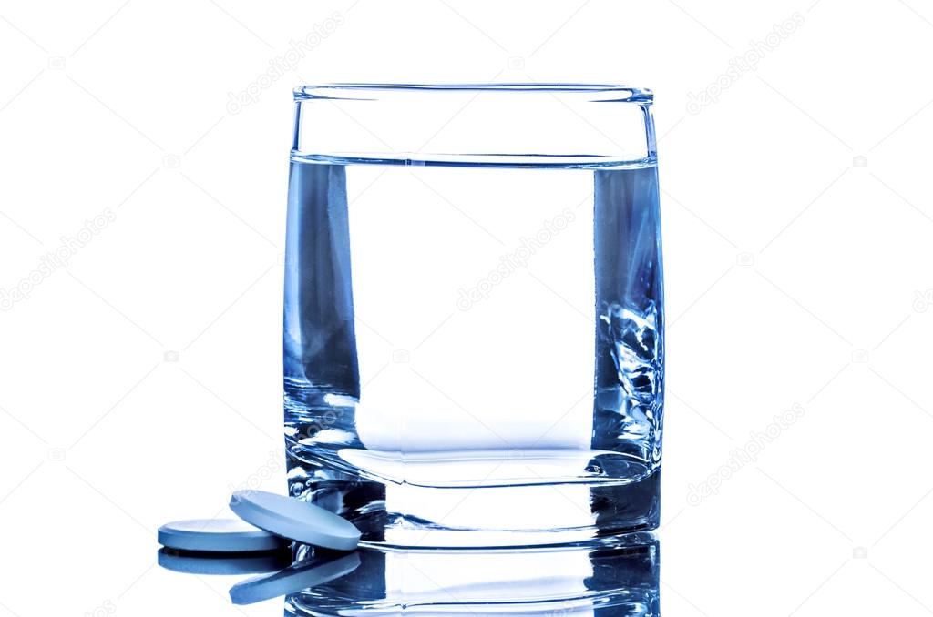 Two tablet near glass of water