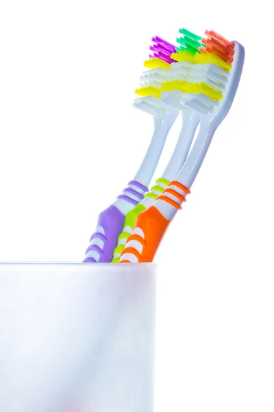 Three colorful toothbrushes in glass — Stock Photo, Image