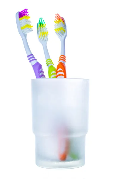 Three colorful toothbrushes in glass — Stock Photo, Image