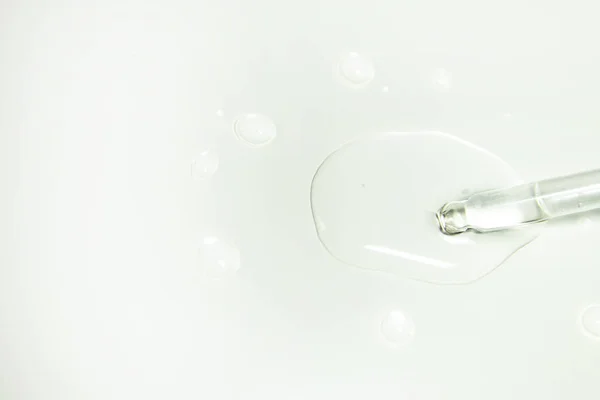 Жидкий гель или сыворотка на экране микроскопа на белом фоне — стоковое фото