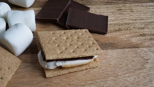 Making s\'mores with graham crackers, chocolate, and marshmallows