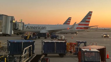 American Airlines uçakları gün batımında Chicago O 'Hare Uluslararası Havaalanı' nın kapısına park ettiler..