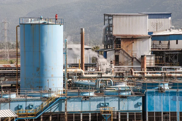 Industrial plant fragment with pipeline and buildings — Stock Photo, Image