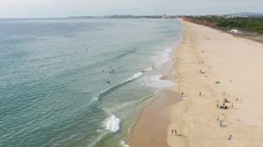 Vilamoura. Portekiz. Turistler kumlu sahil şeridinde güneşli bir günün tadını çıkarıyorlar