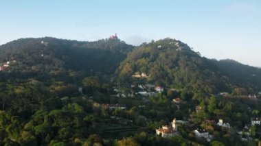 Tepenin tepesinde deniz feneri inşaatı olan yoğun bir yerleşim yeri.