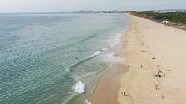 Vilamoura. Portekiz. Turistler kumlu sahil şeridinde güneşli bir günün tadını çıkarıyorlar — Stok video