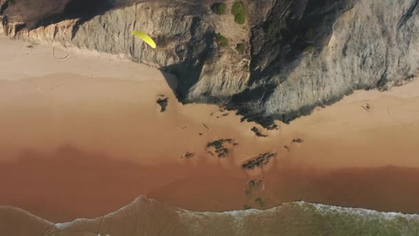 頑丈な海岸をパラグライダーするスポーツマンのドローン映像 — ストック動画