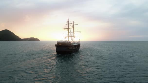 Retrovisore cinematografico della nave storica che naviga verso il tramonto dorato rosa scenico 4K — Video Stock