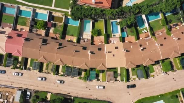 Семейные виллы с красными крышами и бассейнами сзади видны сверху — стоковое видео
