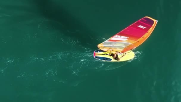 Vue aérienne d'un sportif caucasien adulte attrapant des vagues sur un carton jaune — Video