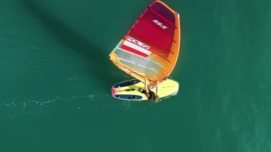 Yetenekli sporcular heyecan verici rüzgar sörfü merkezleri boyunca sörf yapar.