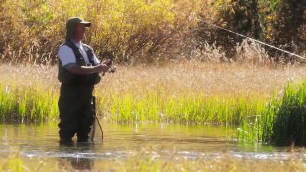 釣りのための釣竿を準備防水パンツの高齢男性4kホビー — ストック動画