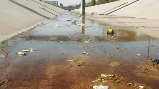 Отвратительный взгляд на человеческий мусор, выброшенный в воду реки Лос-Анджелес, США — стоковое видео