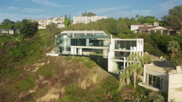 Μοντέρνο σπίτι στο πράσινο γκρεμό ψηλά πάνω από τον Ειρηνικό Ωκεανό με επική θέα στο ηλιοβασίλεμα 4K — Αρχείο Βίντεο