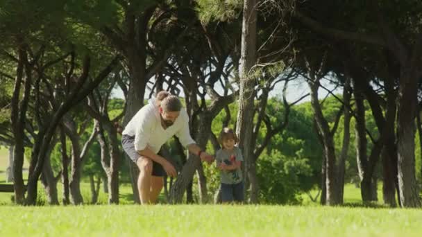 Enfant joyeux courant vers la caméra avec son père en arrière-plan — Video