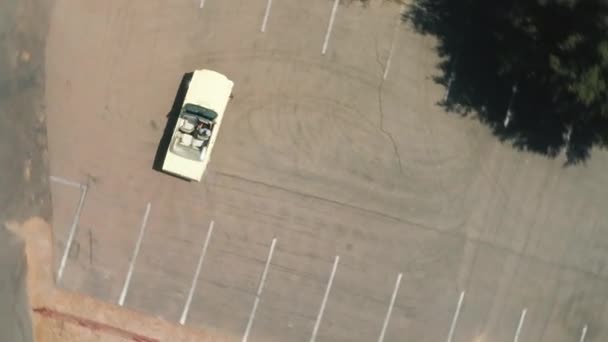 Flygfoto ovanifrån på vintage bil drivande på tom parkeringsplats, USA 4K — Stockvideo
