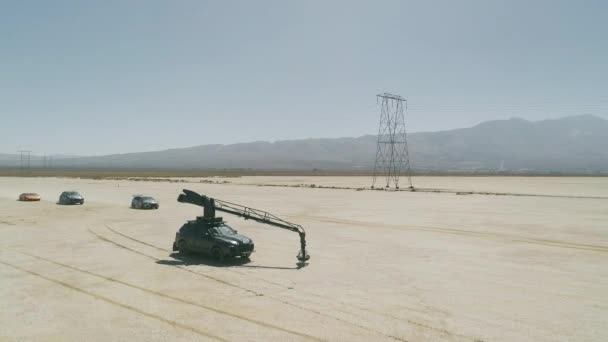 Vue aérienne du processus de tournage, des cicatrices sportives conduisant par des voitures exotiques passant dans le désert — Video