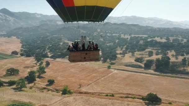Feche a cesta de balão de ar quente com turistas felizes subindo acima da paisagem EUA — Vídeo de Stock