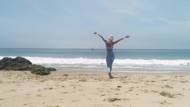 砂浜で朝を楽しむスポーツウェアの若い女性のスローモーション — ストック動画