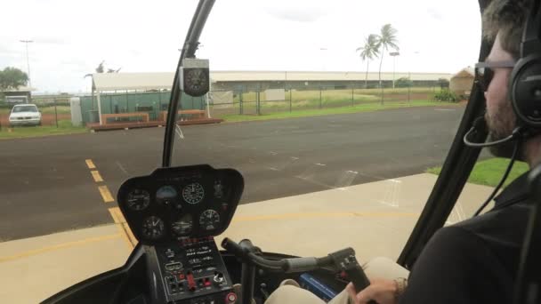 Сосредоточенный пилот осматривается вокруг посадочной полосы, ориентируясь на вертолет, Гавайи Кауаи — стоковое видео