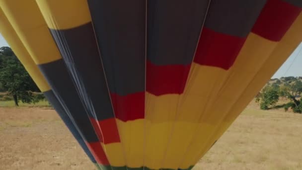Rising drone close up shot of vibrant colorful hot air balloon with happy people — Stock video