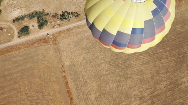 Close-up drone shot van geel rood en blauw hete lucht ballon met mand toeristen — Stockvideo
