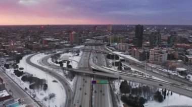 Chicago banliyö otoyolu üzerinde kış boyunca pembe ve mor gün batımı manzarası, 4K hava durumu