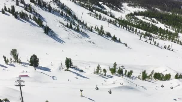 Widok z lotu ptaka na ośrodek narciarski Mammoth z ludźmi snowboarding w dół wzgórza, 4K US — Wideo stockowe