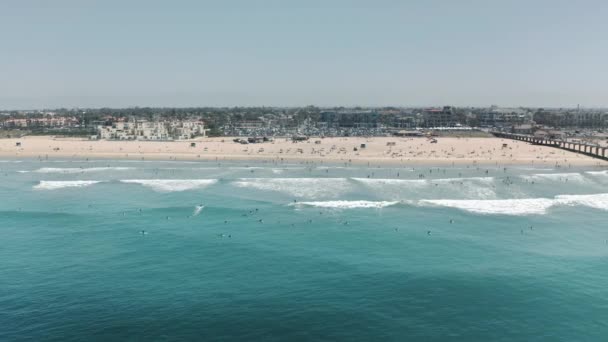 Surfers vangen schuimende golven bij het prachtige zandstrand — Stockvideo