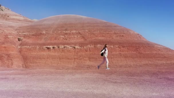 在五彩斑斓的砂岩山蓝天中漫步的电影空中快乐的女人 — 图库视频影像