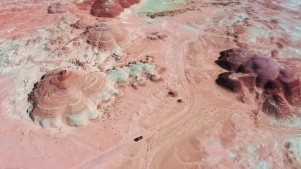 Vista aérea lejana coche conduciendo por rojo Marte con coloridas formaciones onduladas colinas — Vídeos de Stock