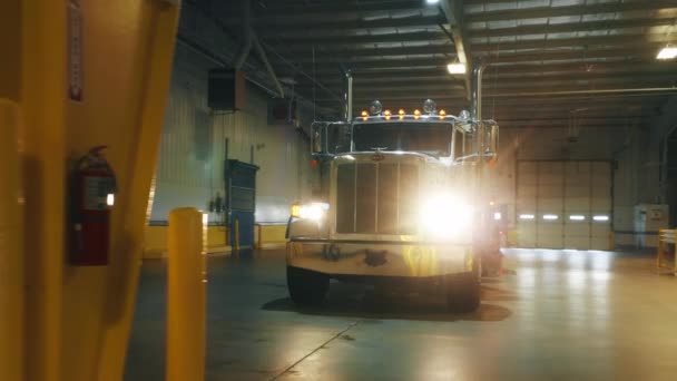 Těžký nákladní vůz s rozsvícenými světlomety při nakládce v garáži, dodávka — Stock video