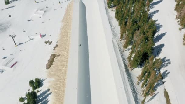 Esquí aéreo 4K y snowboard aéreo a través de los copos de nieve de luz suave, EE.UU. — Vídeo de stock