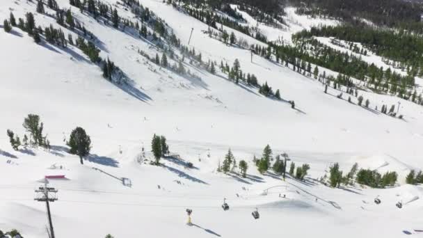 Mammut-Skigebiet in der Luft, Snowboarder fahren bei leichtem Schneefall den Berg hinunter — Stockvideo
