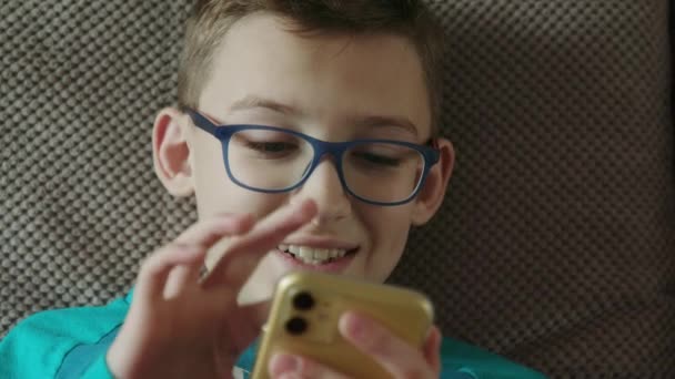 Primer plano de un adolescente, utilizando un teléfono para jugar en interiores — Vídeos de Stock