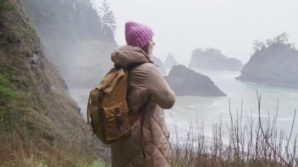Mladá atraktivní žena těší dech beroucí pobřeží krajiny v deštivý den, USA — Stock video