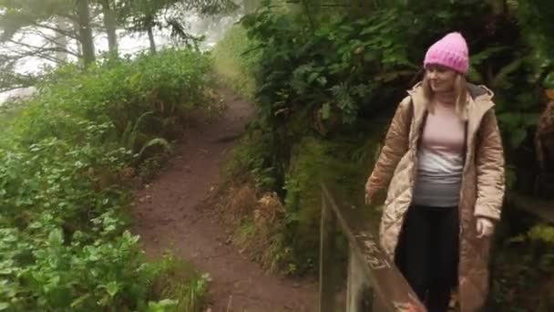 熱帯雨林を通して木製の橋で一人で歩くバックパックを持つ美しい女性 — ストック動画