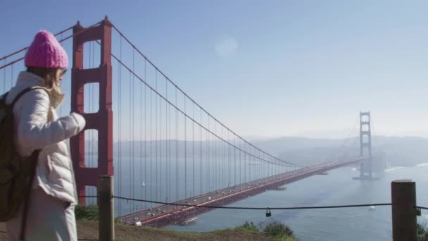 Viajante visitando o marco panorâmico Golden Gate Bridge, desfrutando da baía no dia ensolarado — Vídeo de Stock