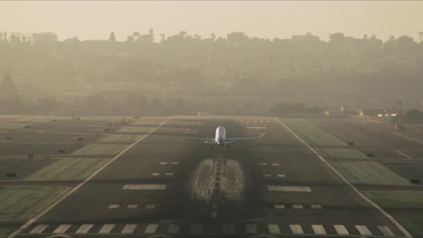 Riesiges Flugzeug hebt von der Landebahn ab, dahinter ein Stadtbild — Stockvideo