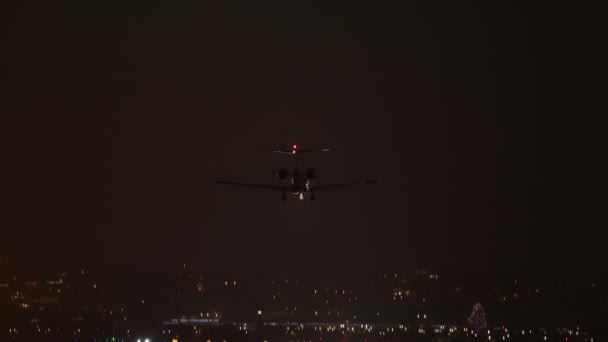 Huge passenger airliner arriving along single runway, lit by colorful lighting — стоковое видео