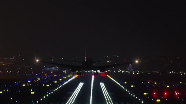 Plane with additional lighting landing over the night city — стоковое видео