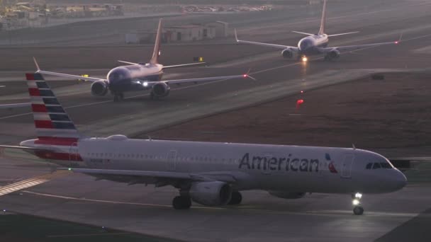 Passenger planes in line before take off at sunset — Stock Video