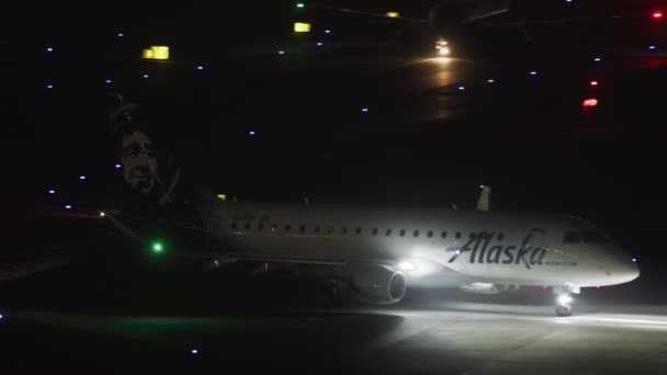 Vliegtuig bereidt zich voor om op te stijgen in verlichte luchthaven 's nachts — Stockvideo