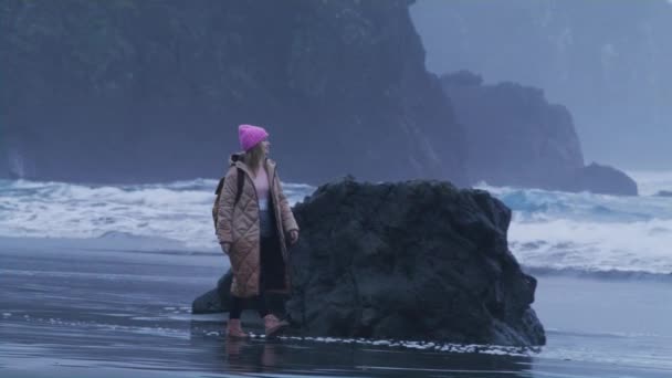 Woman traveler relaxing, walking by the cinematic rocky beach with scenic rocks — Stockvideo