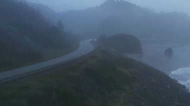 Uçurumun kenarında gri gökyüzünün ötesine giden arabaların hava görüntüleri.