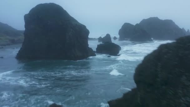 Fırtınalı denizin köpüklü dalgalarıyla kayalara çarpan hava görüntüleri. — Stok video