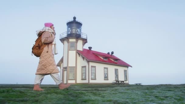 Slow motion woman tourist walking at lighthouse building on parallax background — Vídeo de Stock