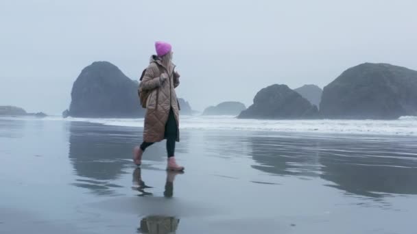 曇りの灰色の日に美しいオレゴン海岸のビーチ、ビーチで歩く女性｜4K — ストック動画