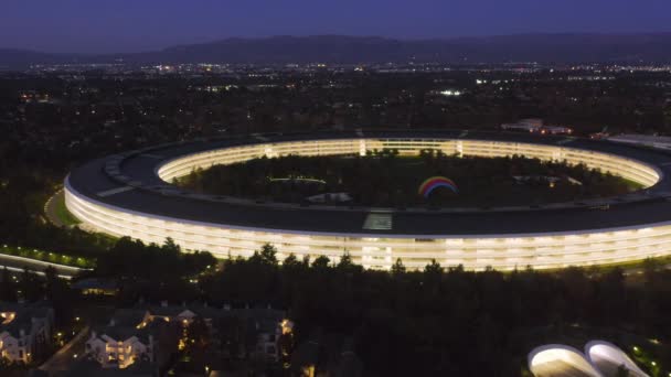 Zoom nella vista aerea degli uffici open space vuoti nella sede centrale di Apple di notte 4K — Video Stock